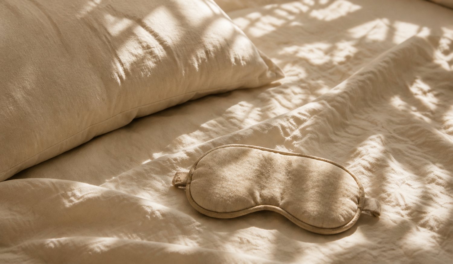 Schlafmaske auf einem Bett im warmen, gestreiften Sonnenlicht